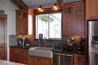Thumb kitchen  craftsman style  cherry  medium color  recessed panel  craftsman glass grid door panel at the top  farm sink  apron sink  tall cabinet  full overlay