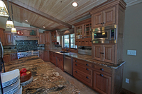 Thumb kitchen  craftsman style  quartersawn oak  medium color  flush mount  glass  wood hood  appliance garage  diagonal corner cabinets  micro in upper cabinet  cup rack  front dovetail drawers
