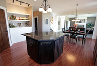 Thumb kitchen  shaker style  knotty alder  black accent island  recessed panel  staggered heights  angled island  overhang on island  micro hood  stanadrd overlay