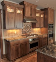 Thumb kitchen  shaker style  quartersawn oak  recessed panel  dark color  glass top panel  staggered heights  angled bottom above range hood  full overlay