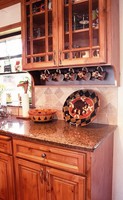 Thumb kitchen  traditional style  knotty alder  medium color  glazed  raised panel doors  recessed panel drawers  glass grid doors  cup rack  standard overlay