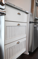 Thumb kitchen  traditional style  painted walnut with sand through  wainscot panel  bank of drawers  5 piece fronts  full overlay