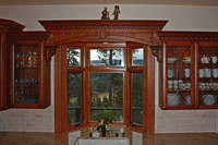 Thumb kitchen  traditional style  western maple  cherry color  raised panel  arched window valance with panels  glass doors with leaded seeded glass  carved crown  corbels  bay window  standard overlay